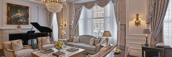 The living room at the Georgian Suite with a sofa, a marble coffee table and two armchairs; and the grand piano in the back.