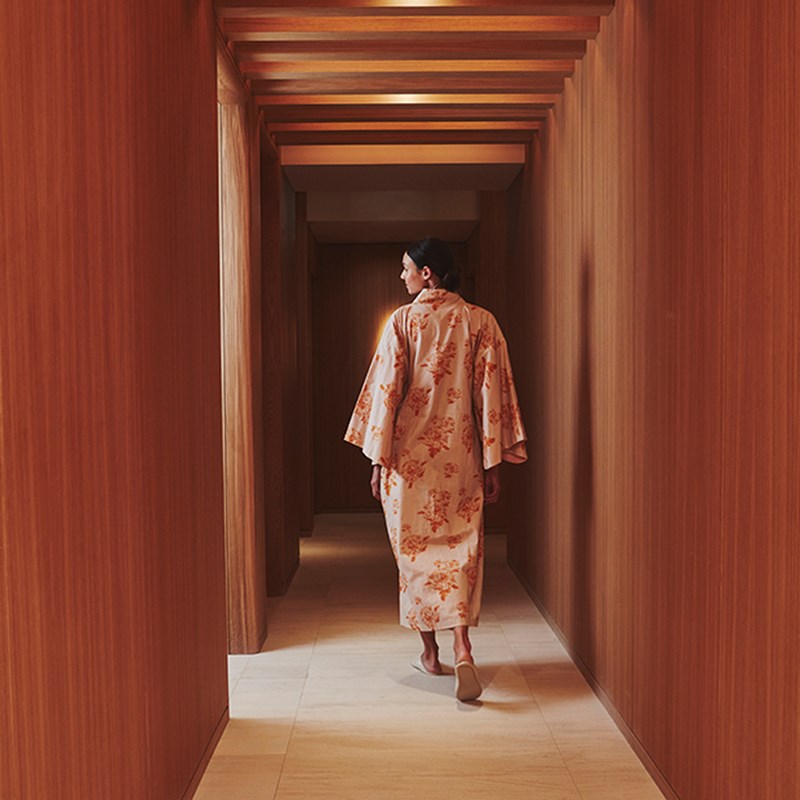 Corridor in Claridge's Spa with a woman walking away from the camera. She is wearing a kimono .