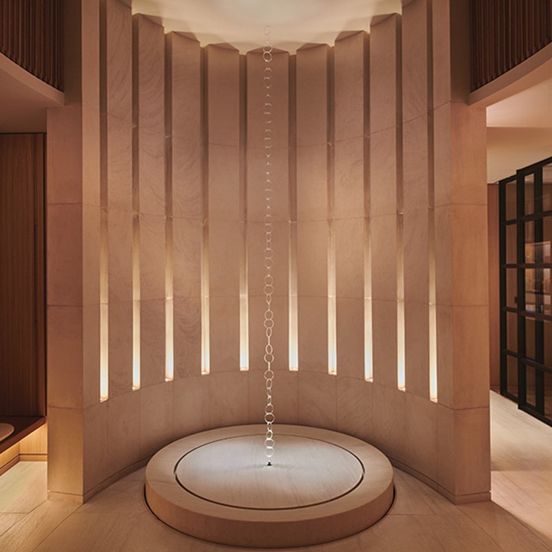 The entrance to Claridge's Spa which is a tall sculpture with a vertical chain and wood surrounds