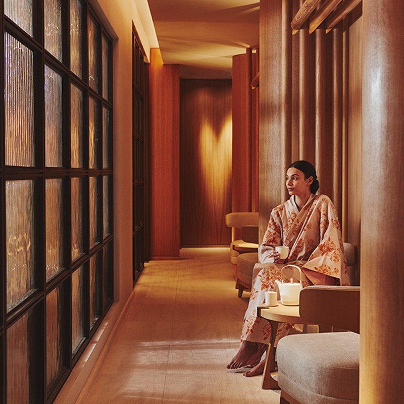 Model wearing a Claridge's Spa kimono and drinking tea in the waiting area